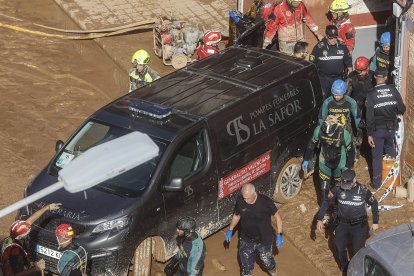 Un furgón de la funeraria sale de un garaje con cadáveres localizados tras el paso de la DANA,