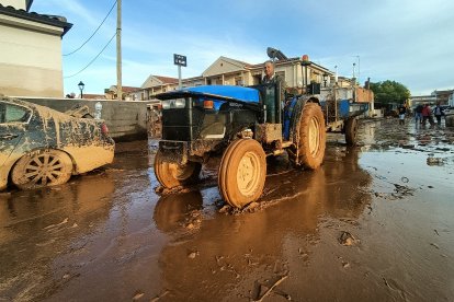 Un señor con su tractor colabora en la limpieza de las calles, a 1 de noviembre de 2024, en Utiel.