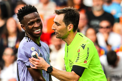 De Burgos Bengoetxea habla con Vinicius en el partido entre Valencia y Real Madrid del 21 de mayo de 2023.