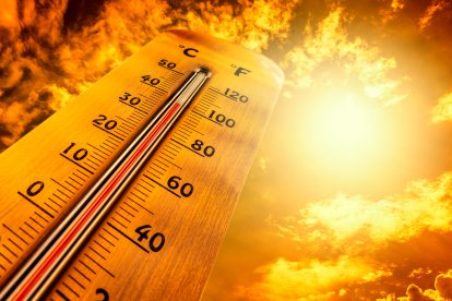Termómetro marcando altas temperaturas durante una ola de calor, bajo un cielo anaranjado