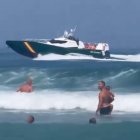 Patrullera de la Guardia Civil junto a los bañistas en la playa de Levante del Peñón de Gibraltar.