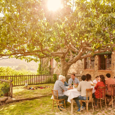 Comida familiar en el jardín de una casa rústica: así se vive el intercambio de casas, con autenticidad.