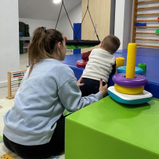 Una profesional con un menor de atención temprana.