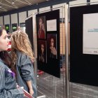 Una joven observa las fotografías expuestas en la Estación de Alicante.