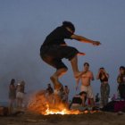 Una persona salta una hoguera durante la noche de San Juan, en la playa de la Malvarrosa / Jorge Gil.