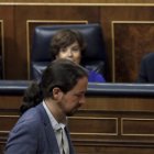 Iglesias pasa por delante del escaño de Rajoy durante el debate.