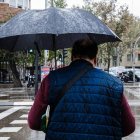 Un hombre se protege con su paraguas de la lluvia provocada por la borrasca Ciarán.