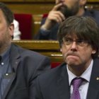 Puigdemont y Junqueras, en el Parlament, con gesto serio.