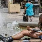 Un hombre se refresca en una fuente del centro de Valencia para soportar las altas temperaturas, a 12 de julio de 2021, en Valencia, Comunidad Valenciana (España).