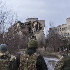 Soldados ucranianos, delante de edificios destrozados en la primera línea del frente en el Donbás. (Getty/Brendan Hoffman)