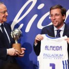 José Luis Martínez-Almeida recibe, de parte de Florentino Pérez, una camiseta del Real Madrid de baloncesto.