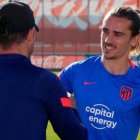 Griezmann, aún sin cortarse el pelo, saluda a Simeone en el entrenamiento de esta mañana.