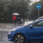 Una mujer lleva un carrito de bebé mientras se protege de la lluvia con un paraguas, - Rober Solsona - Europa Press