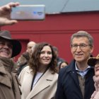 La presidenta de la Comunidad de Madrid, Isabel Díaz Ayuso, y el líder del PP, Alberto Núñez Feijóo, se hacen fotos con simpatizantes durante un paseo por la Plaza Mayor.