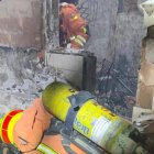 Los bomberos en la vivienda incendiada en Alfafar.