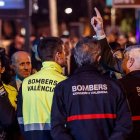 Felipe VI conversa con bomberos y miembros de los fuerzas y cuerpos de seguridad del estado mientras contempla el esqueleto del edificio calcinado en el incendio de Campanar.