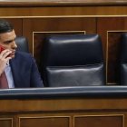 El presidente del Gobierno y líder del PSOE, Pedro Sánchez, habla por teléfono en el Congreso de los Diputados.