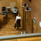 Imagen de los asientos de Vox en el pleno del Ayuntamiento de València vacíos tras abandonar sus ediles la sesión y de una de las representantes de este partido saliendo de la sala.