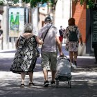 Archivo - Una pareja de ancianos camina por la calle con un carro de compra, a 27 de julio de 2021, en Madrid, (España). La Seguridad Social destinó en el presente mes de julio la cifra récord de 10.202,29 millones de euros al pago de pensiones contributi.