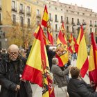 Varias personas sostienen banderas de España en una concentración franquista.