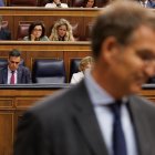 En primer plano el líder del PP, Alberto Núñez Feijóo; y al fondo el presidente del Gobierno, Pedro Sánchez, en el Congreso.