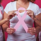 Mujeres con Cáncer de Mama sujetan el lazo rosa que representa la enfermedad.