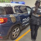 Una agente de la Policía Nacional junto a un coche patrulla.