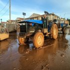 Un señor con su tractor colabora en la limpieza de las calles, a 1 de noviembre de 2024, en Utiel.