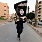 Un combatiente del ISIS con la bandera del Estado Islámico