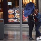 Dos chicas intentan controlar su paraguas