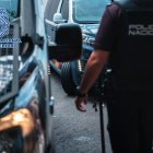 Archivo - Imagen de archivo de un agente de la Policía Nacional junto a varios vehículos policiales.