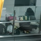 Varias personas se preparan para pernoctar en la T4 del Aeropuerto Adolfo Suárez-Madrid Barajas, a 12 de mayo de 2025, en Madrid (España).