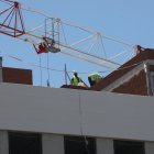Archivo - Dos obreros trabajan en la construcción de un edificio de viviendas en Madrid.