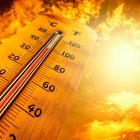 Termómetro marcando altas temperaturas durante una ola de calor, bajo un cielo anaranjado