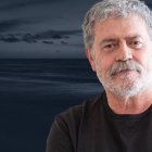 Retrato del psicólogo Walter Riso con expresión reflexiva, frente a un fondo oscuro de mar y cielo nublado.