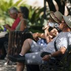 Dos personas con ropa veraniega y sombreros en Málaga.
