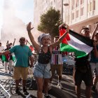 Varias personas con banderas de Palestina irrumpen la Gran Vía antes de pasar la etapa 21 de la Vuelta Ciclista a España.