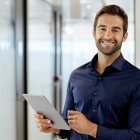 Un trabajador en oficina consulta el calendario laboral desde su dispositivo digital para planificar sus vacaciones por días sueltos, una opción legal si se pacta con la empresa.