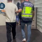 Agentes de la Policía Nacional junto a uno de los detenidos