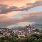 El perfil de Hervás al caer la tarde, con sus tejados rojizos y la silueta de la iglesia de Santa María, enmarcado por el cielo otoñal del Valle del Ambroz.
