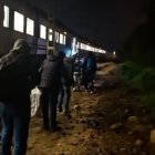 Pasajeros siendo trasladados a otro tren en mitad de la noche.