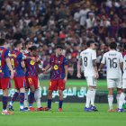 JEDDAH, SAUDI ARABIA - JANUARY 11: Raphinha of FC Barcelona is held back by Raul Asencio of Real Madrid during the Spanish Super Cup Final between FC Barcelona and Real Madrid at King Abdullah Sports City Hall Stadium on January 11, 2026 in Jeddah, Saudi Arabia. (Photo by Yasser Bakhsh/Getty Images)