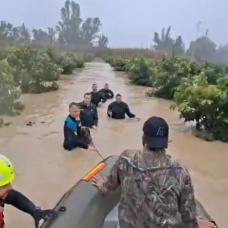 Agentes del Grupo Especial de Actividades Subacuáticas de la Guardia Civil evacuando a una persona por la crecida del río Guadalete en Jerez.