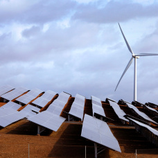 Campo con placas solares y un molino