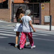 Una choca joven pasea con una mujer mayor por la calle.