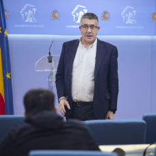 El portavoz del PSOE en el Congreso, Patxi López, durante una rueda de prensa en el Congreso con Vito Quiles de fondo.