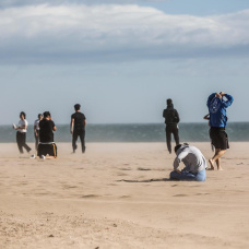 Varias personas en la playa de la Malvarrosa con fuertes rachas de viento