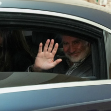 Felipe VI, se despide desde el coche oficial tras una visita.