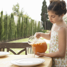 Una niña vierte gazpacho en una jarra