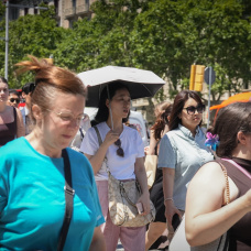 Varias personas se protegen del sol durante una jornada de altas temperaturas provocada por la ola de calor.